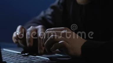 危险的黑客在笔记本电脑上打字，窃取机密信息，网络犯罪